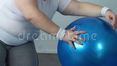 精疲力竭的胖子带着健身球<strong>摔倒在地</strong>板上，缺乏运动能量